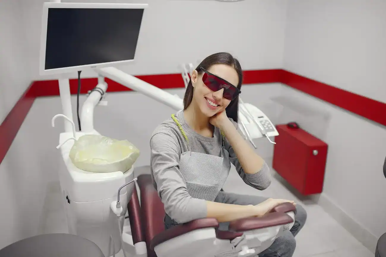 Happy female patient relaxing post Zoom Laser Teeth Whitening treatment in a modern dental office Coventry